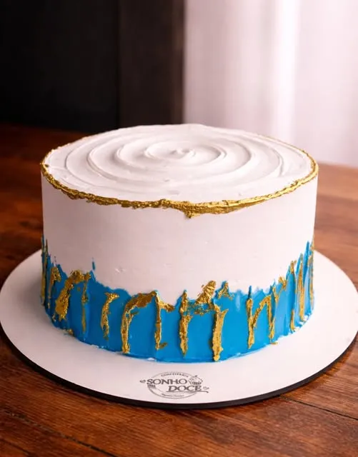 Bolo branco com faixa azul e dourada